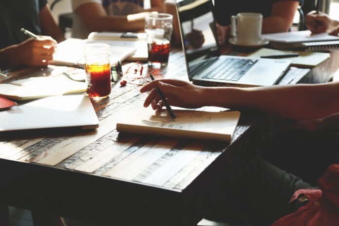 A woman journaling at a desk with financial documents, symbolizing values-based financial planning